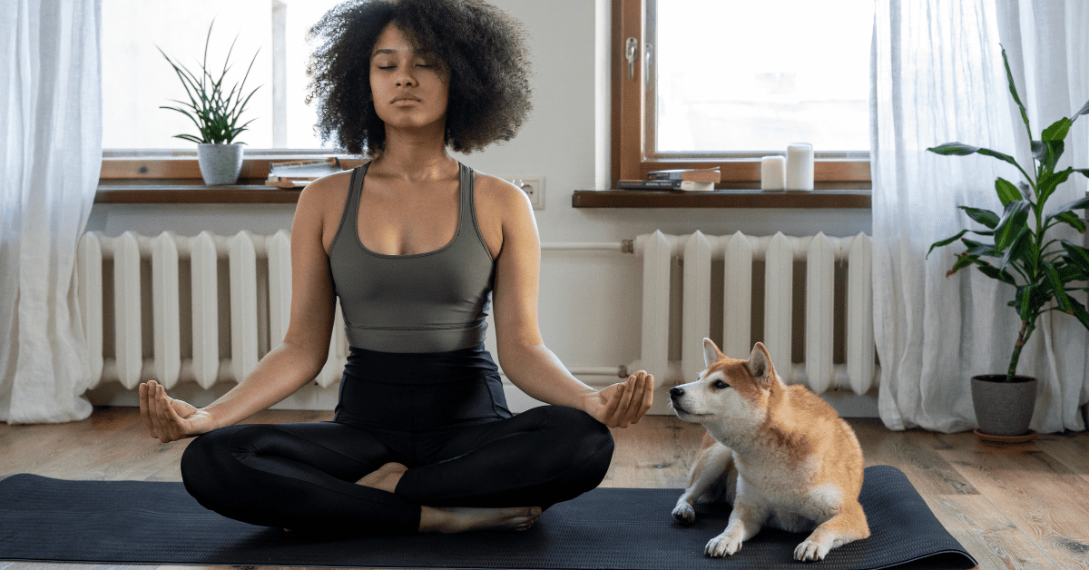 A girl along with a dog doing yoga