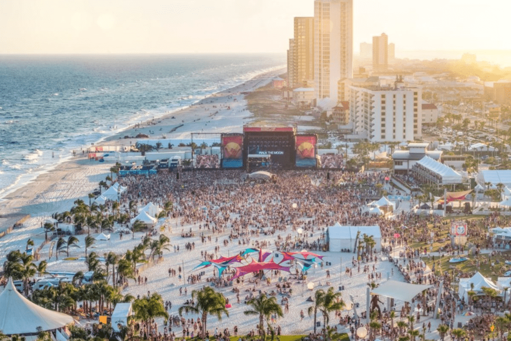 A crowd of people on the beach at sunset.