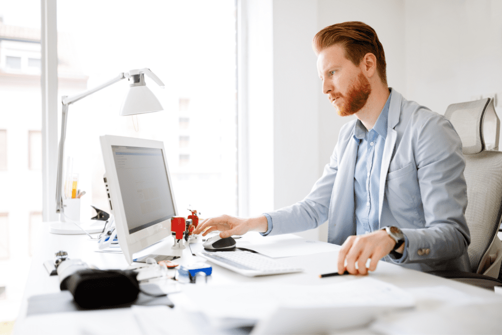 A man sitting at his desk working on a computer.