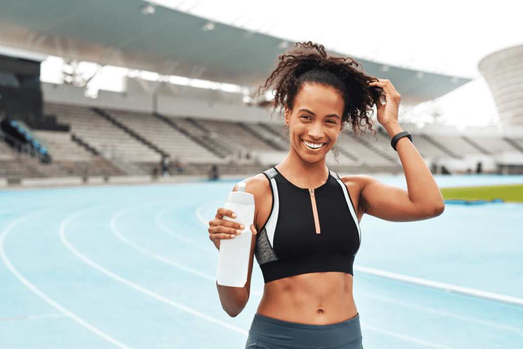 A woman is holding up her hair while standing on the track.