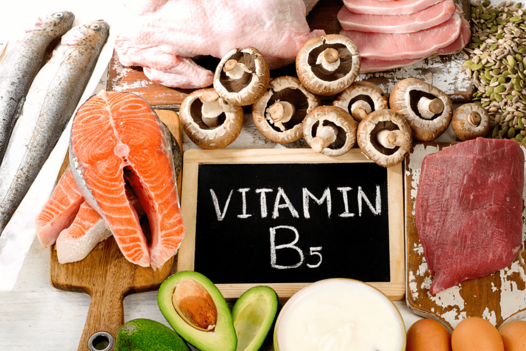 A table topped with meat and vegetables next to the word vitamin b 5.